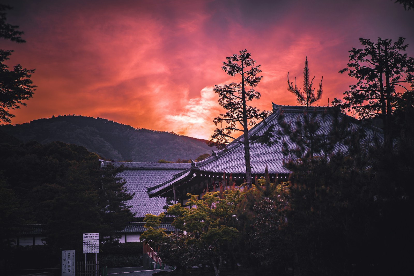 A temple in Kyoto beneath a pink sunset sky