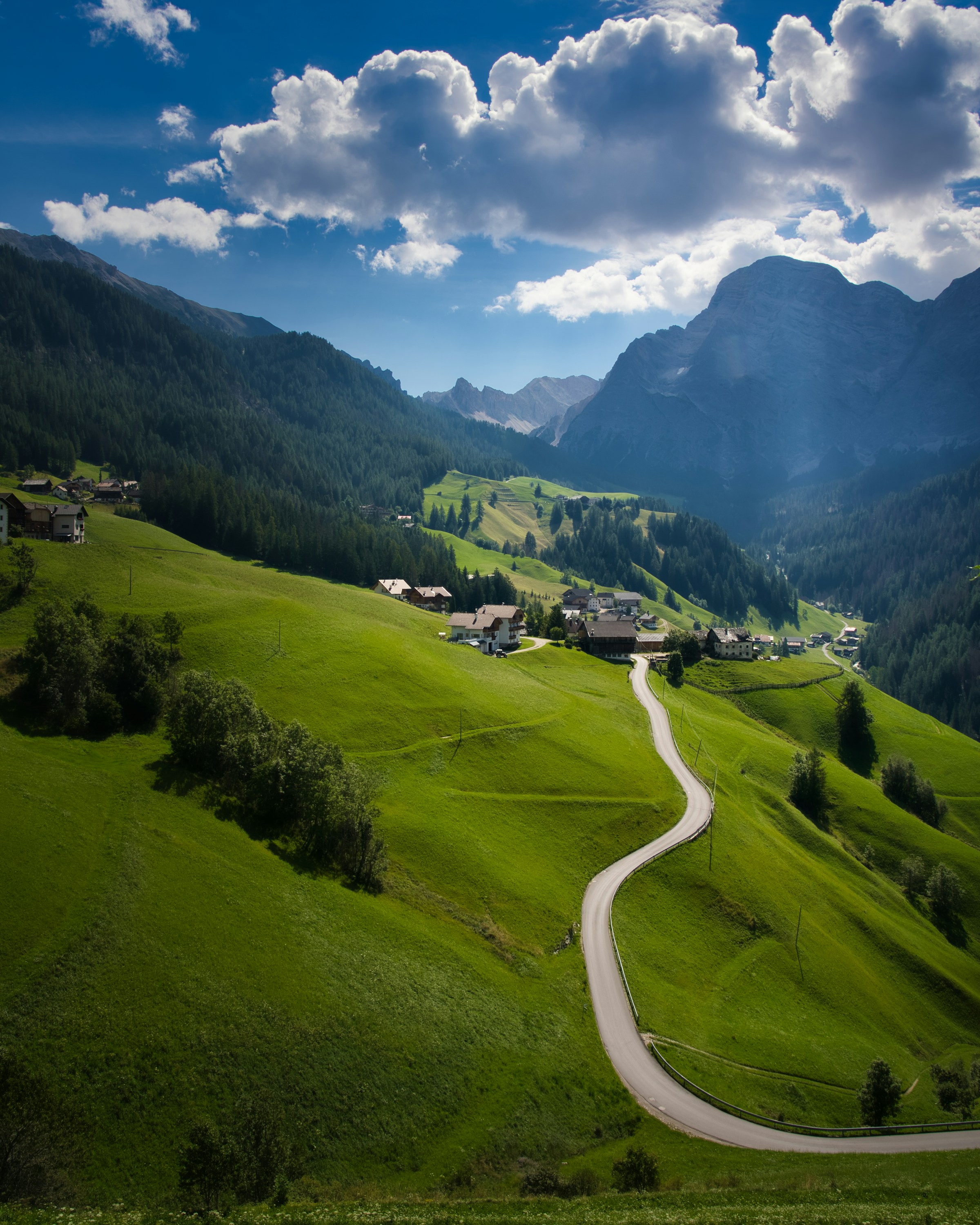 A mountain road winding toward the Dolomites